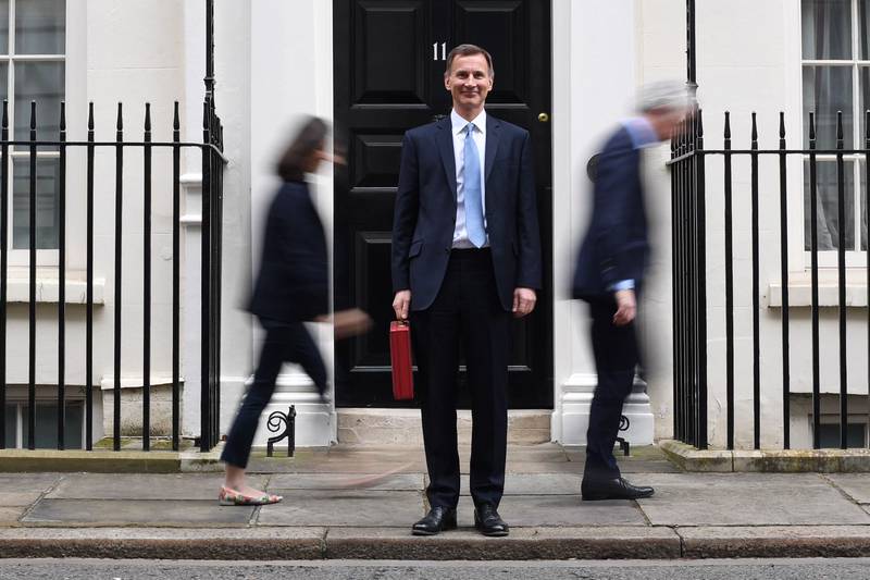 Britain's Chancellor of the Exchequer Jeremy Hunt posed with the red budget box as he left 11 Downing Street in London on Wednesday to present the annual budget. AFP