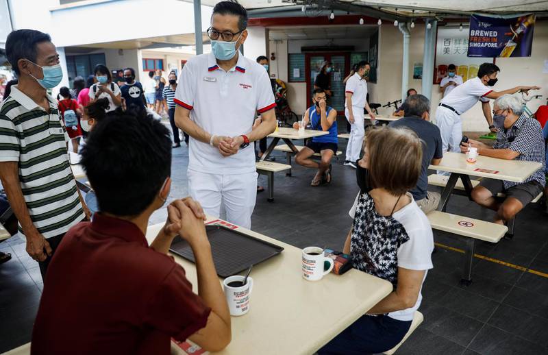 Raymond Lye and Ng Chee Meng of the People's Action Party (PAP) meet with residents during a walkabout ahead of the general election in Singapore on Sunday. Reuters