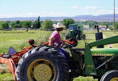 Janie VanWinkle drives a tractor as she collects hay for her cows. The drought has meant she needs more hay than usual to keep her cattle healthy.
