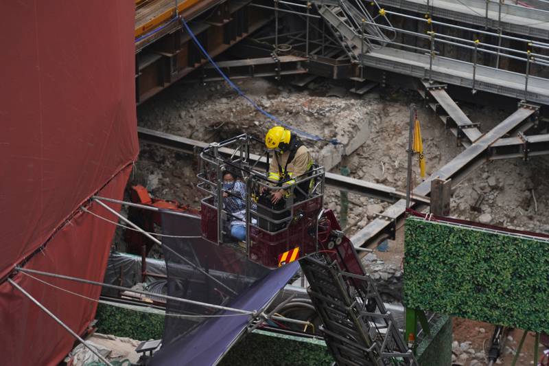 A firefighter rescues one of those trapped by the fire at the World Trade centre in Hong Kong. Reuters