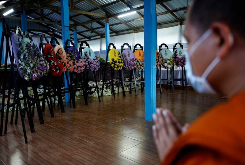 A Thai Buddhist monk offers prayers in front of the wreath from the Thai king and royal family.  EPA 