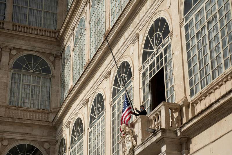 A member of the Swiss Guard raises the US flag above the San Damaso Courtyard. AFP