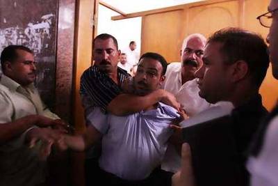 A Mamdouh Ismail is removed from the court after a scuffle with victims' relatives.