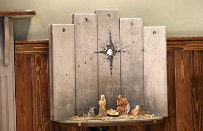 epa08086584 A view of a new artwork by elusive British graffiti artist Banksy depicting the nativity scene dubbed 'scar of Bethlehem', displayed in the Walled Off hotel, in the West Bank city of Bethlehem, 22 December 2019.  EPA-EFE/ABED AL HASHLAMOUN *** Local Caption *** 55725073