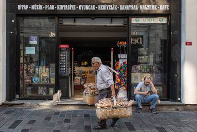 A street vendor passes a book store in Istanbul, Turkey. Recent indicators point to a continued increase in the underlying trend of inflation, the central bank said. Bloomberg