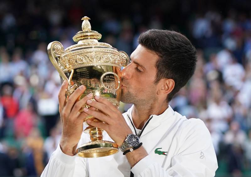 Novak Djokovic of Serbia kisses the trophy after defeating Roger Federer of Switzerland in the men's final at Wimbledon in 2019. The Grand Slam attracts the best players in the world, and a host of celebrities. To see who was there last year, and who will miss out in 2020, swipe the picture. EPA