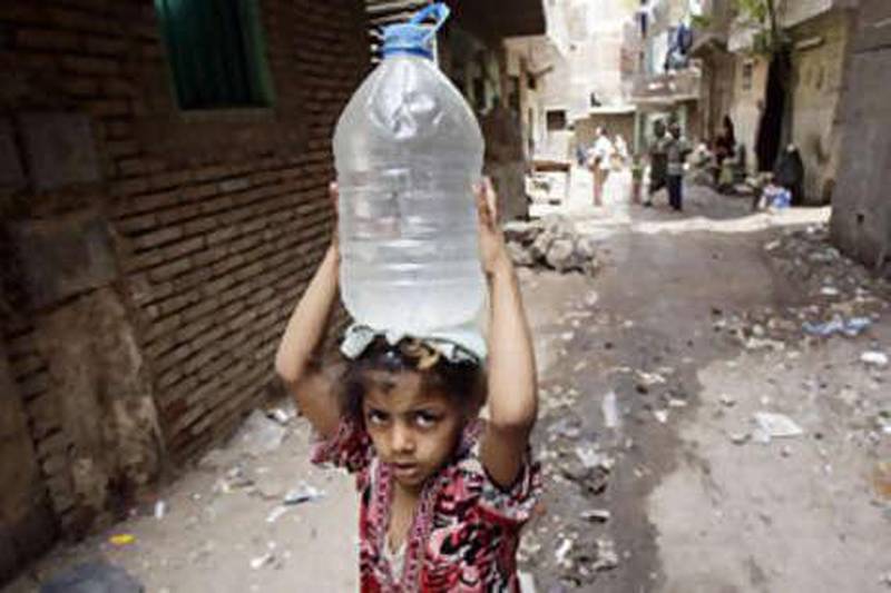 A girl carries a container filled with water from the Nile from a pump in Manshiyet Nasser shanty town in eastern Cairo.