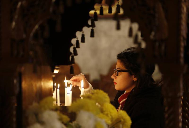 A Palestinian Christian woman lights a votive candle during Orthodox Christmas celebrations at the Saint Porphyrios Greek Orthodox church in Gaza City. Mohammed Abed / AFP Photo