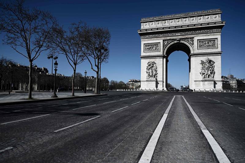 An empty street leading to the Arc de Triomphe in Paris.  AFP