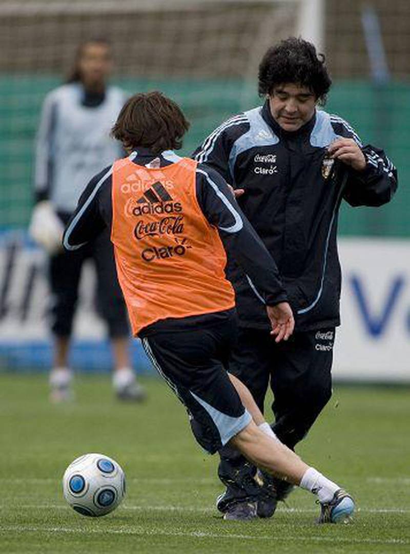 Lionel Messi swerves past his coach, Diego Maradona, during training for tomorrow's World Cup match against Brazil.