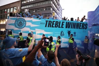 Fans take photos as the Manchester City bus passes through Manchester. Reuters
