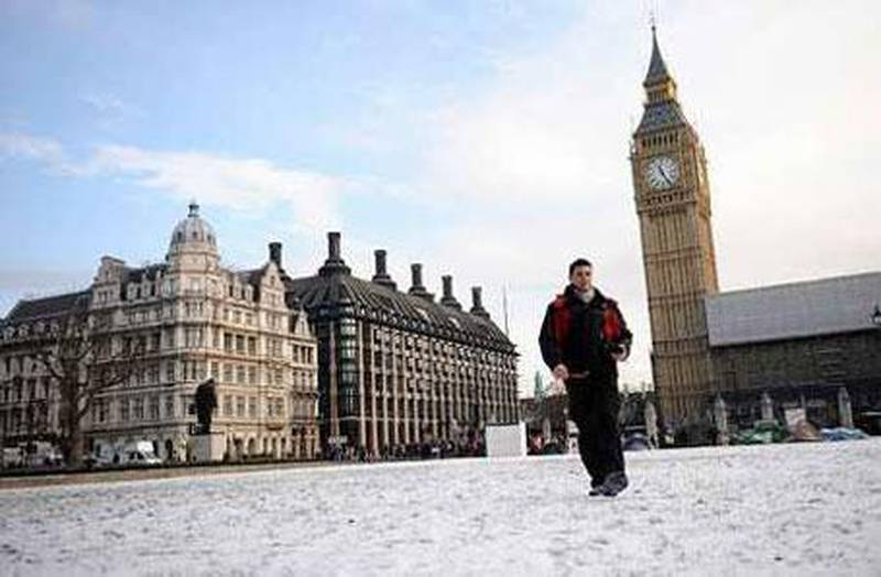 A man makes his way across a snowy Parliament Square in London.