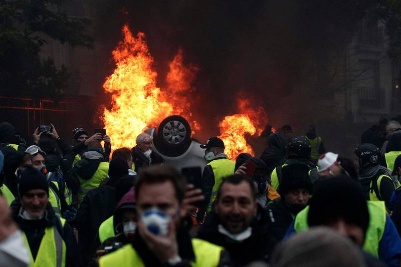 epa07206136 Cars burn as protesters wearing yellow vests (gilets jaunes) clash with riot police near the Arc de Triomphe as part of a demonstration over high fuel prices on the Champs Elysee in Paris, France, 01 December 2018 (issued on 03 December 2018). The so-called 'gilets jaunes' (yellow vests) protest movement, which reportedly has no political affiliation, is protesting across the nation over high fuel prices. According to reports, the damage left after the riots in Paris are estimated to exceed three to four million euro.  EPA/YOAN VALAT