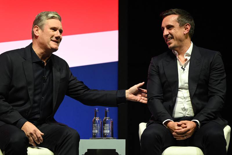 Mr Starmer, left, and former England football player Gary Neville speak on the main stage on the second day of the annual Labour Party Conference. AFP