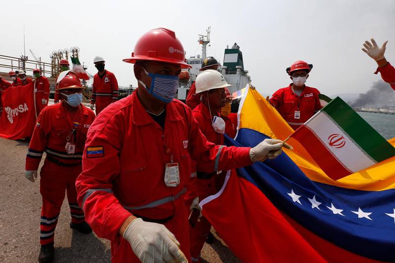 A Venezuelan oil worker holding a small Iranian flag attends a ceremony for the arrival of Iranian oil tanker Fortune at the El Palito refinery near Puerto Cabello, Venezuela. AP Photo