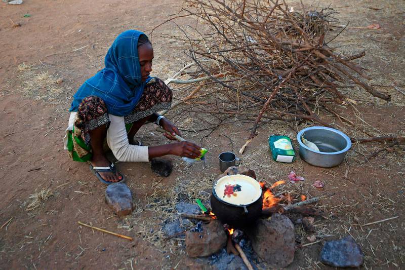 An Ethiopian refugee who fled fighting in Tigray province prepares food at the Um Rakuba camp in Sudan's eastern Gedaref province. AFP
