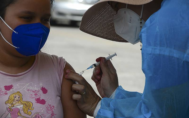 A girl receives the first dose of the Pfizer/BioNTech Covid-19 vaccine in Tegucigalpa during a vaccination programme for teens aged 12 to 15.