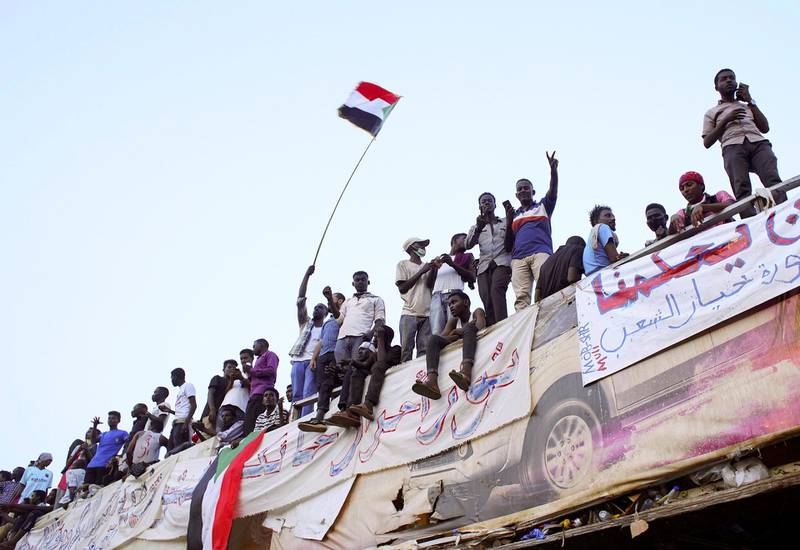 Demonstrators wave their national flag as they attend a protest rally demanding Sudanese President Omar Al-Bashir to step down outside Defence Ministry in Khartoum, Sudan April 10, 2019. REUTERS/Stringer   NO RESALES. NO ARCHIVES