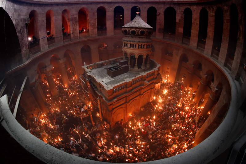 Christian Orthodox worshippers hold up candles lit from the ‘Holy Fire’ as they gather in the Church of the Holy Sepulchre in Jerusalem’s Old City on April 27, 2019 during the Orthodox Easter. The ceremony celebrated in the same way for eleven centuries, is marked by the appearance of "sacred fire" in the two cavities on either side of the Holy Sepulchre. / AFP / THOMAS COEX
