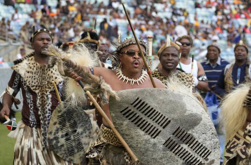 Zulu men sing and dance as they arrive for a coronation event. AP
