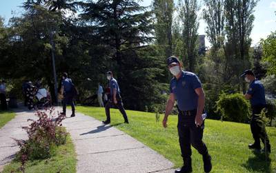 Police officers wearing face masks to protect against the spread of coronavirus, patrol in a public garden, warning people to respect social distancing, in Ankara. AP Photo