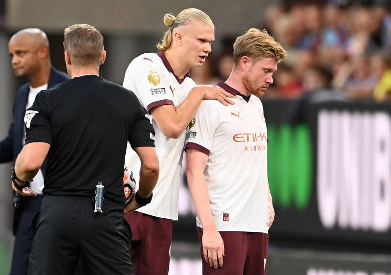 Erling Haaland consoles Manchester City teammate Kevin De Bruyne as the Belgian midfielder leaves the pitch injured during the win at Burnley. Getty