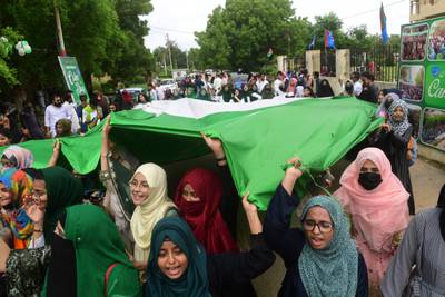 Students carry a giant flag of Pakistan during a march as the celebrations begin early in Karachi. AFP