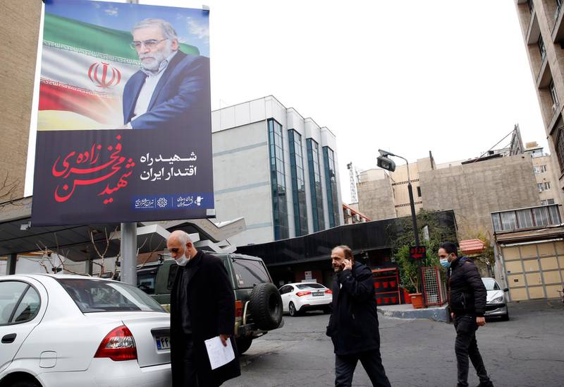 Iranians walk past next to a huge poster of Iranian nuclear scientist Mohsen Fakhrizadeh in a street in Tehran. EPA