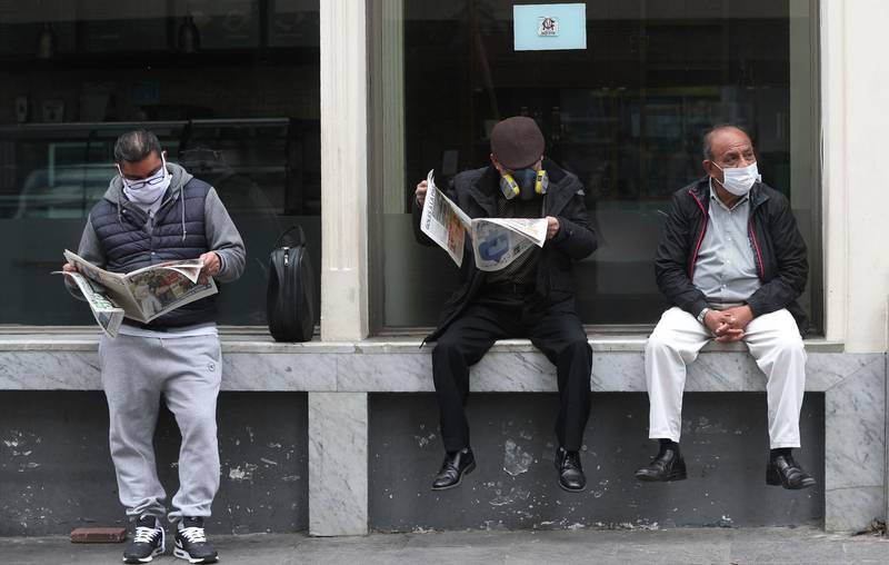 People wearing masks to curb the spread of the new coronavirus wait for businesses to open in downtown Lima, Peru. AP Photo