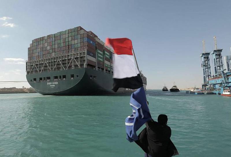 A man waves the Egyptian flag after the Panama-flagged MV 'Ever Given' container ship was fully dislodged from the banks of the Suez. AFP