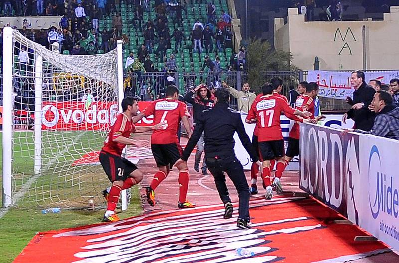 Egyptian Al-Ahly players escape from the field as fans of Al-Masry team rush after them during riots that erupted after the football match between the two teams in Port Said, 220 kms northeast of Cairo, on February 1, 2012. At least 73 people were killed and hundreds injured in the violence that erupted as soon as the referee blew the final whistle in the match. AFP PHOTO/STR
 *** Local Caption ***  778025-01-08.jpg