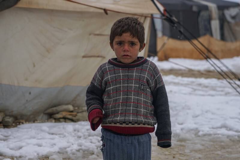 A child braves the cold in a camp for the displaced