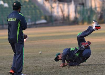 Pakistani cricketer Mohammad Amir dives to catch the ball during a training session in Lahore on Thursday. Arif Ali / AFP / December 24, 2015