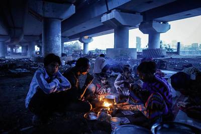A migrant family sit around a fire warming themselves and preparing breakfast under a flyover in Mumbai. Danish Siddiqui / Reuters