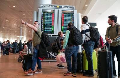 Travellers look at a monitor displaying delayed flights. Reuters