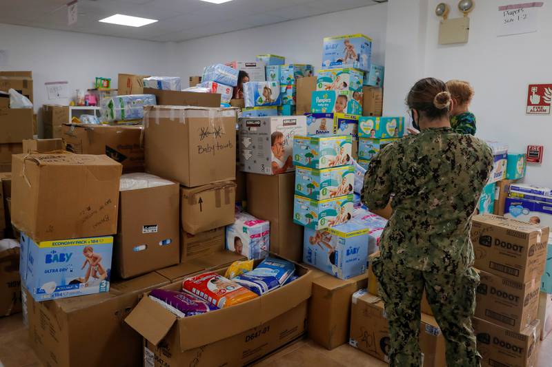 A US navy sailor stands next to boxes containing nappies and towels for Afghan children, who have been evacuated from Kabul, in Rota, southern Spain. Reuters