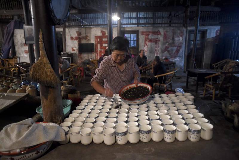 An elderly woman preparing tea for customers at a hundred-year-old teahouse in the early morning in Chengdu, southwest China's Sichuan province. The 50-seat teahouse in Chengdu, capital of Sichuan province, and the way of life it represents are a throwback to the past in a society that is becoming increasingly frenetic and internationalised by its status as the world's second-largest economy. Wang Zhao/AFP