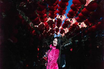 A woman poses for a picture under red lanterns in Ditan park during Lunar New Year celebrations in Beijing.  AFP