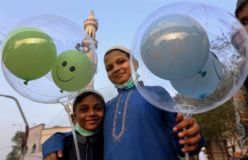 Boys hold balloons after performing an Eid al-Fitr prayer at a mosque in Karachi, Pakistan. AP Photo