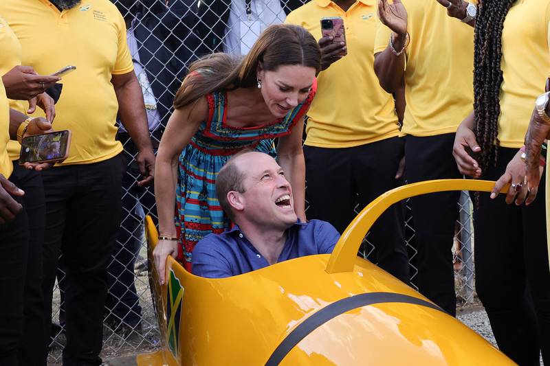 Prince William laughs as they enter the team's bobsleigh. PA