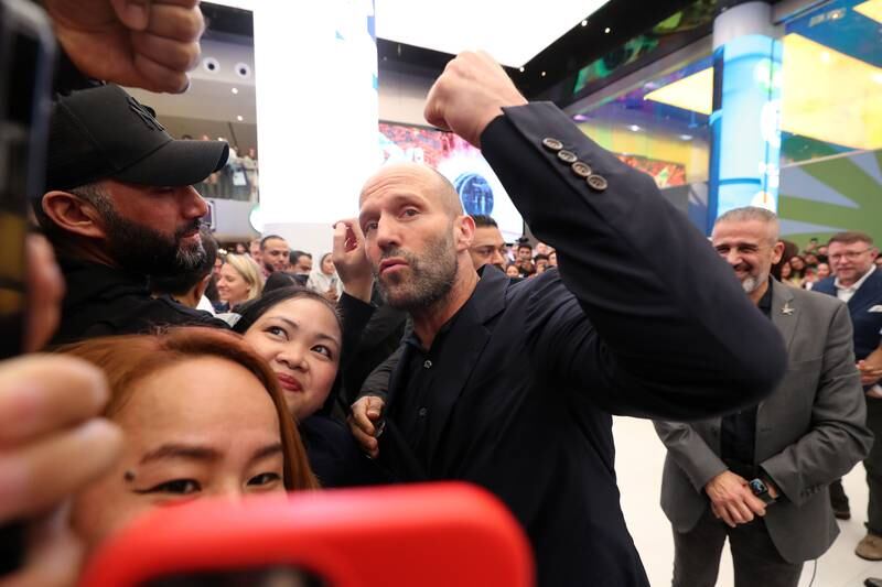 Statham poses with fans at the event