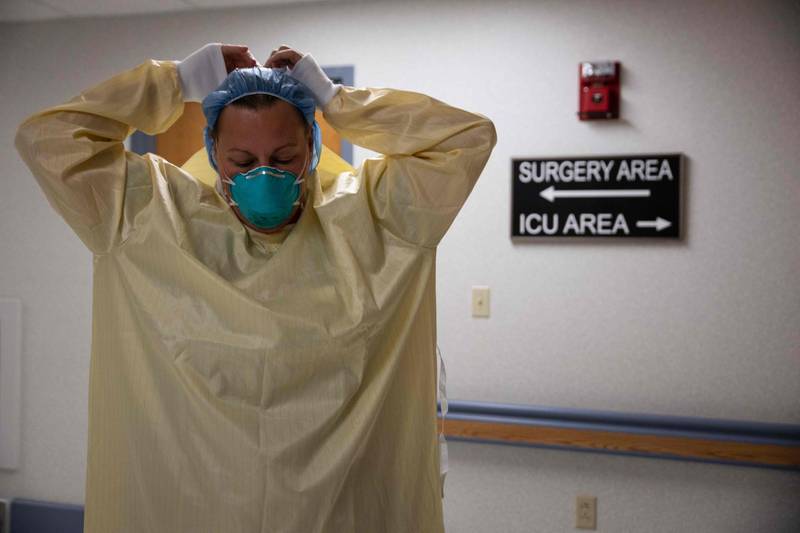 A healthcare professional suits up with PPE (Personal Protective Equipment) to enter a Covid-19 patient's room in the ICU at Van Wert County Hospital in Van Wert, Ohio on November 20, 2020. As Covid-19 numbers spike across Ohio, rural hospitals and staff take on the rising number of patients being admitted. / AFP / Megan Jelinger
