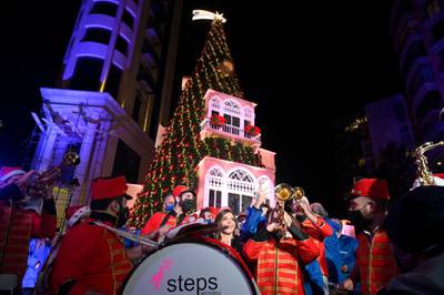 Lebanese people gather next to a giant Christmas tree which has been officially lit up at the Ashrafieh area in Beirut. EPA