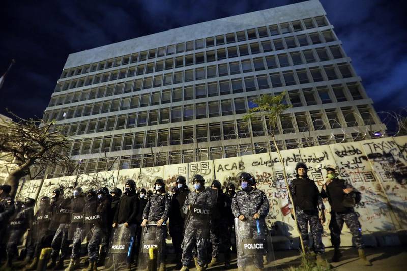 Riot police line up outside the headquarters of the Lebanese central bank during an anti-government demonstration in Beirut.  Bloomberg