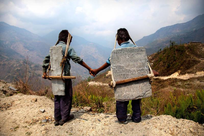 In the Himalayas, Lisa Kristine captured these brothers carrying slate down the mountainside. Below, trucks are waiting to take the slate and eventually sell it. “We all knowingly or unknowingly participate in slavery every day," said Kristine at a conference in London, noting that the slate these boys are carrying may be used in our homes.