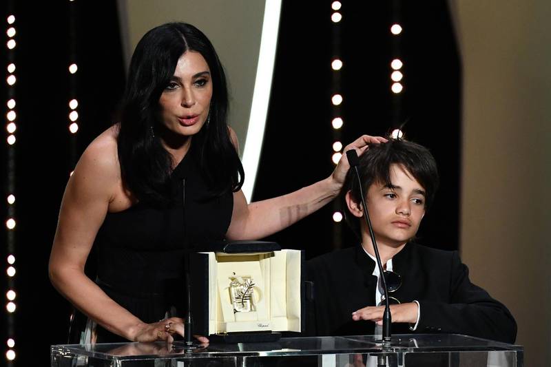 TOPSHOT - Lebanese director and actress Nadine Labaki (L) delivers a speech on stage next to Syrian actor Zain al-Rafeea after 
she was awarded with the Jury Prize for the film "Capharnaum" on May 19, 2018 during the closing ceremony of the 71st edition of the Cannes Film Festival in Cannes, southern France.  / AFP / Alberto PIZZOLI
