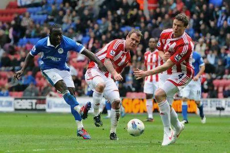 Victor Moses, left, who scored Wigan’s second goal, fires in a shot under pressure from Stoke’s Glenn Whelan.