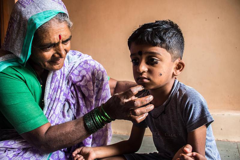 In India, even young children wear kohl. There’s a superstitious belief that wearing kohl wards off the evil eye. In this photo, Kusum is applying kohl to her grandson, Yash, 5.