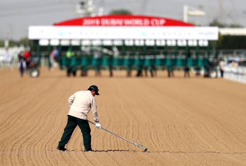 DUBAI, UNITED ARAB EMIRATES - MARCH 30: A groundsmen prepraes to the sand prior to a race during the Dubai World Cup at Meydan Racecourse on March 30, 2019 in Dubai, United Arab Emirates. (Photo by Francois Nel/Getty Images)