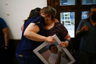 Two women hug while holding a photograph of a nurse at the General Hospital No 6 of the Mexican Institute of Social Security who died of Covid-19 a year ago, at a mausoleum in Ciudad Juarez, Mexico. Reuters